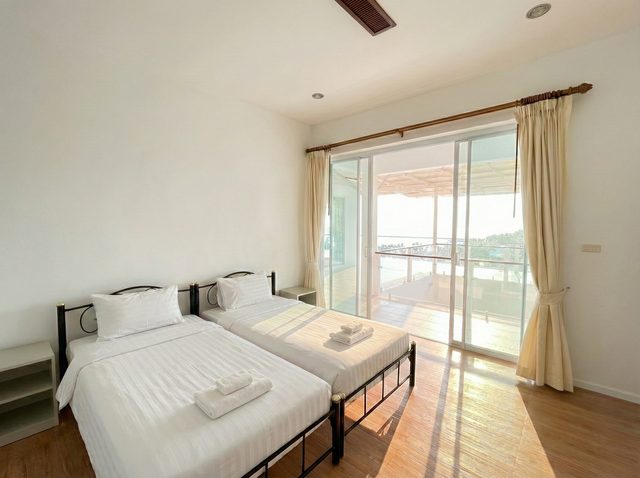 Naturally lit twin bedroom looking towards the sea