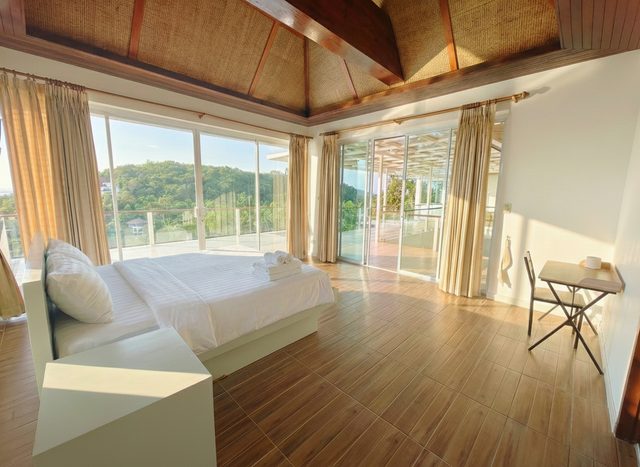 Double bedroom with a high decorative ceiling and panoramic glazing